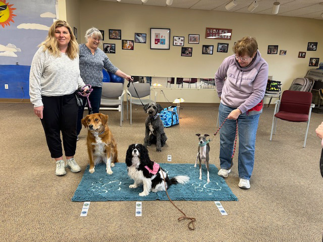Tricks Class—all earned their Intermediate Tricks Title. From the top going clockwise: Rhanda Campbell and Jasper, Theresa Schreiner and Marilyn, Sophie and Kelly Gherardini (not pictured), and Amber Pflueger and Meadow.